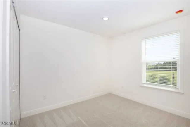 a large white kitchen with stainless steel appliances kitchen island granite countertop a stove and a sink