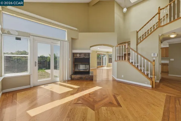 a view of a livingroom with wooden floor and a fireplace