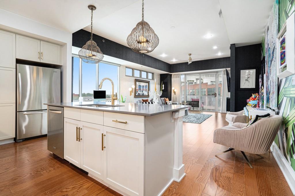 1100 Howell Mill Road Northwest, Unit 808 Atlanta, GA 30318 - Photo 22 of 48 a kitchen with stainless steel appliances granite countertop a refrigerator a sink dishwasher a dining table and chairs with wooden floor