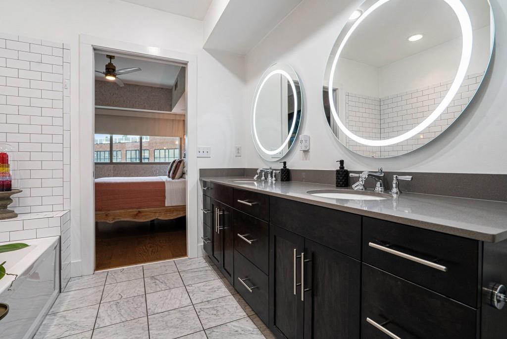 1100 Howell Mill Road Northwest, Unit 808 Atlanta, GA 30318 - Photo 25 of 48 a en suite bathroom with a double vanity sink and a mirror