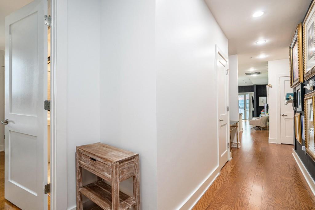 1100 Howell Mill Road Northwest, Unit 808 Atlanta, GA 30318 - Photo 29 of 48 a view of a hallway with wooden floor and a living room