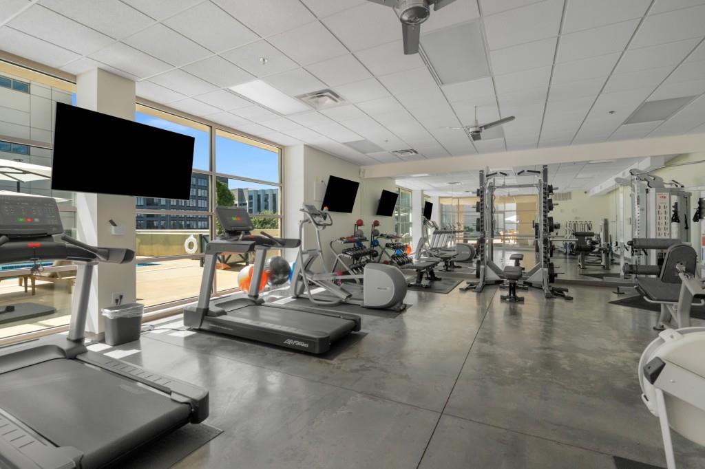 1100 Howell Mill Road Northwest, Unit 808 Atlanta, GA 30318 - Photo 40 of 48 a room with gym equipment and a flat screen tv