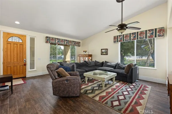 a living room with furniture and two windows