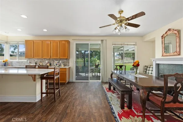 a very nice looking living room with a large window wooden floor and stainless steel appliances