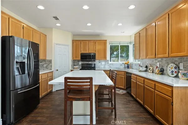 a kitchen with stainless steel appliances granite countertop a refrigerator stove microwave and sink