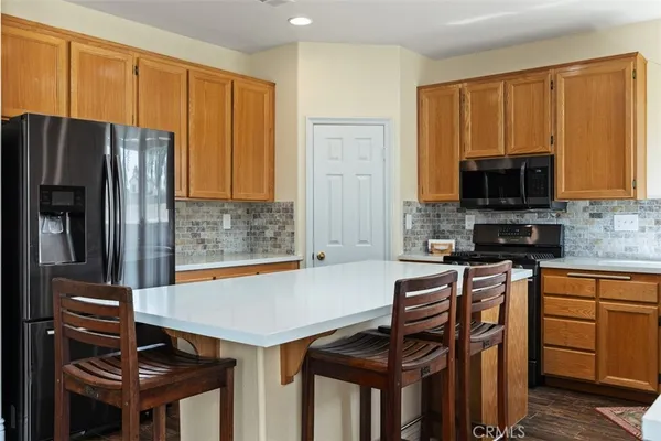 a kitchen that has a microwave a stove and a refrigerator