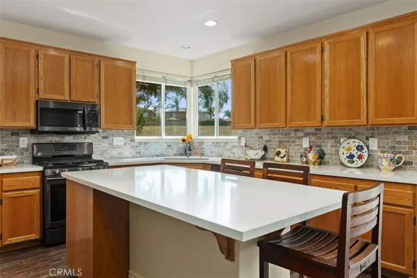 a kitchen with stainless steel appliances granite countertop a sink a stove microwave and cabinets
