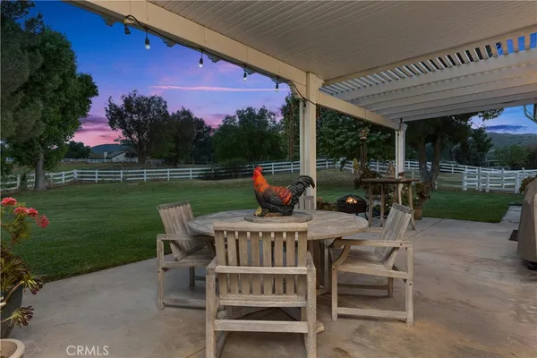a view of a patio with a table chairs and a yard