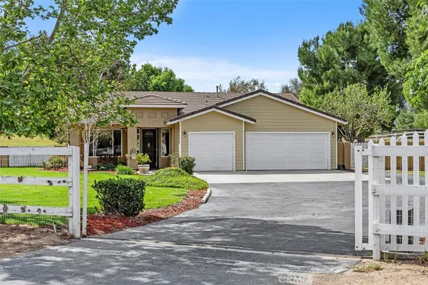 a house with a yard plants and large tree