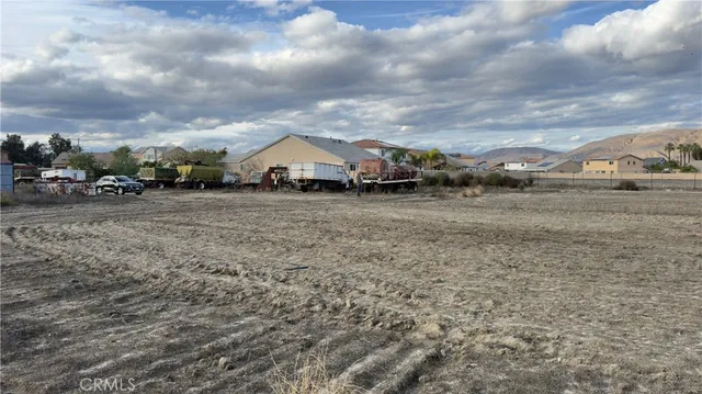 a view of a dry yard with wooden fence