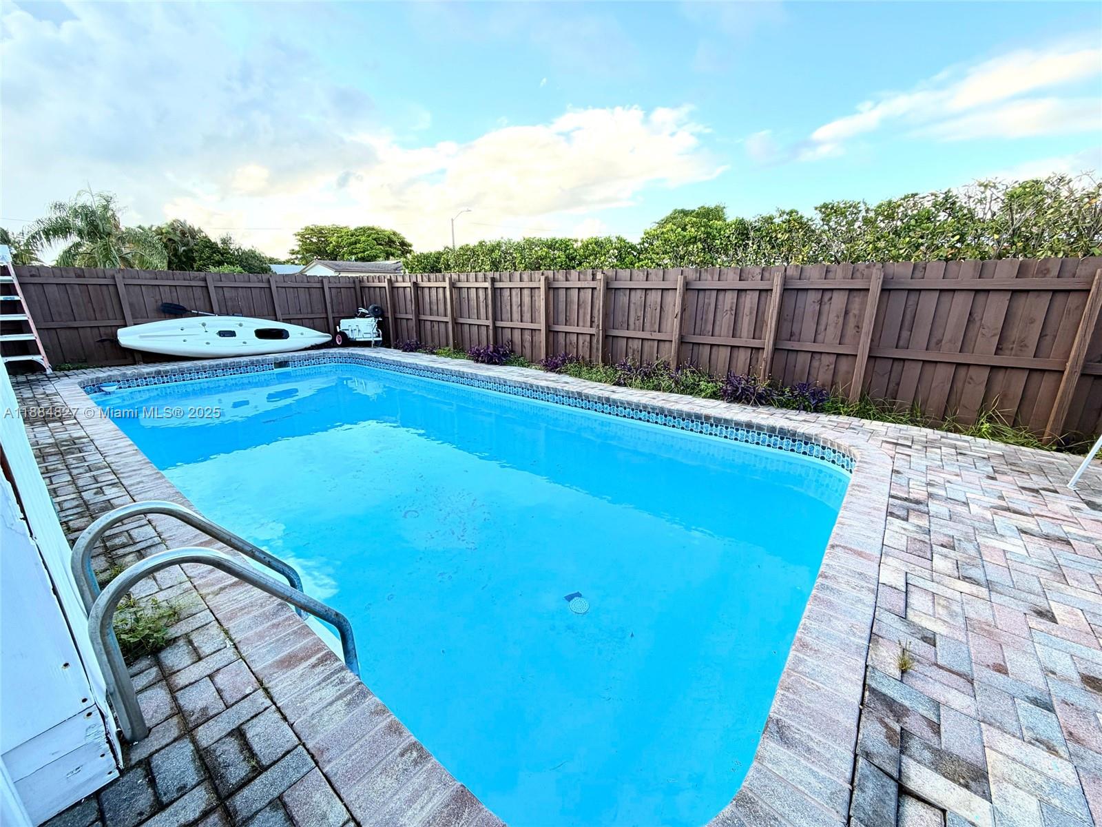 401 Southeast 5th Street Dania Beach, FL 33004 - Photo 8 of 9 a swimming pool with wooden fence