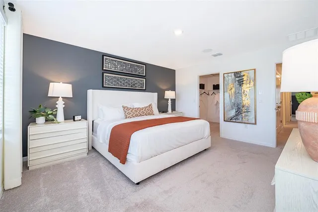 a spacious bedroom with a bed and a cabinets