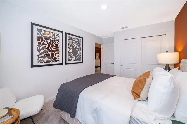 a bath room with a toilet a sink and a large mirror
