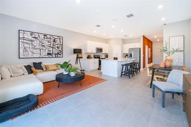 a living room with furniture kitchen view and a table