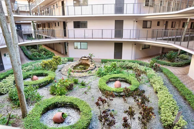 a view of a backyard with plants and a lawn chair with swimming pool