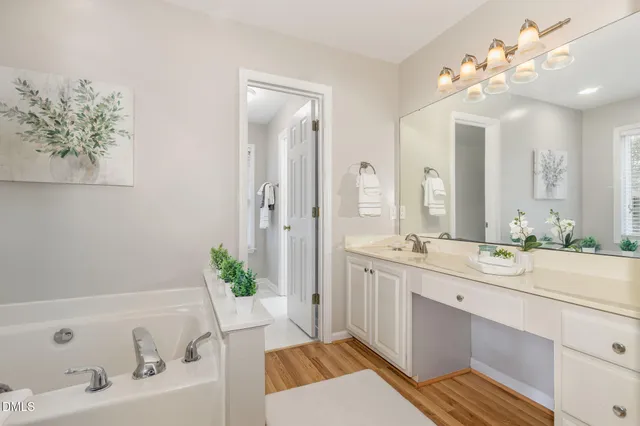 a spacious bathroom with a double vanity sink mirror and bathtub