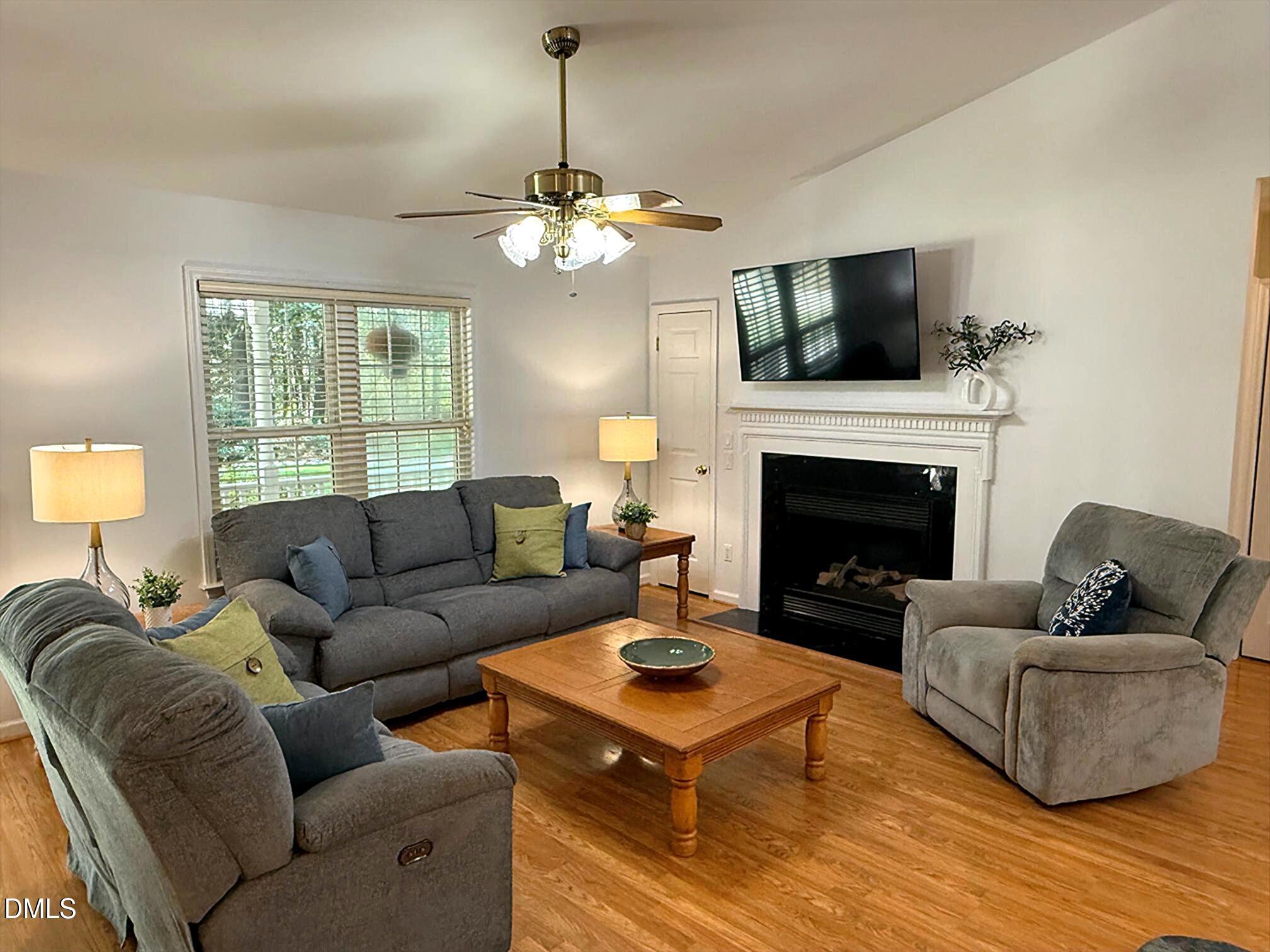 127 Cobble Brook Drive Rougemont, NC 27572 - Photo 2 of 48 a living room with furniture a fireplace and a flat screen tv