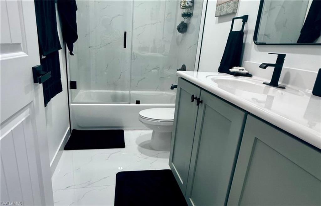 14122 Southwest 276th Street Homestead, FL 33032 - Photo 18 of 47 Bathroom featuring combined bath / shower with glass door, vanity, and marble finish floors