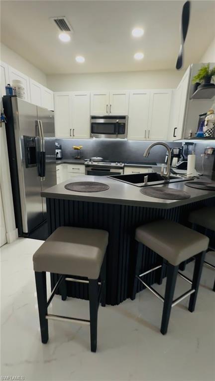 14122 Southwest 276th Street Homestead, FL 33032 - Photo 19 of 47 Kitchen featuring dark countertops, a kitchen bar, stainless steel appliances, open shelves, and recessed lighting