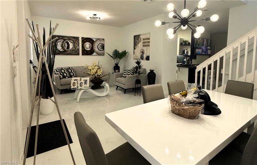 14122 Southwest 276th Street Homestead, FL 33032 - Photo 7 of 47 Dining area featuring stairway and a chandelier
