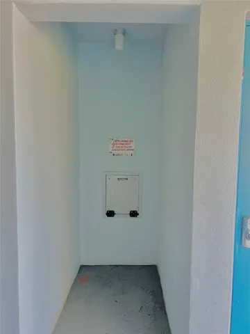 a view of a swimming pool with a lawn chairs under palm trees