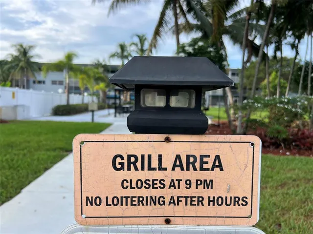 a sign that is sitting on a grass in front of the house
