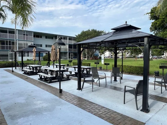 a view of a patio with a table and chairs under an umbrella with a patio