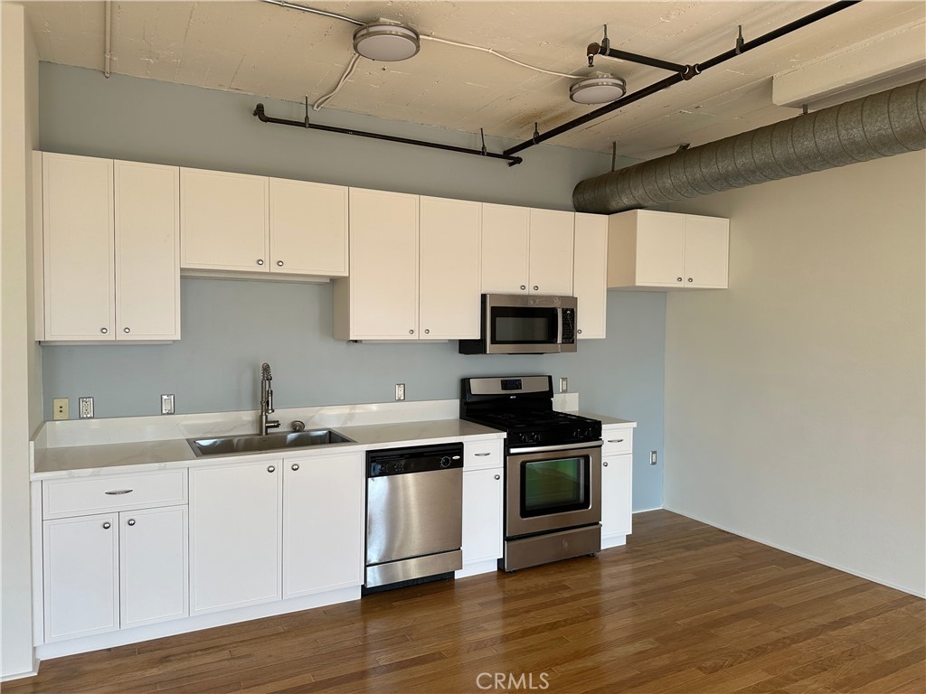 200 North San Fernando Road, Unit 313 Los Angeles, CA 90031 - Photo 5 of 29 a kitchen with stainless steel appliances granite countertop a sink a stove a microwave and cabinets