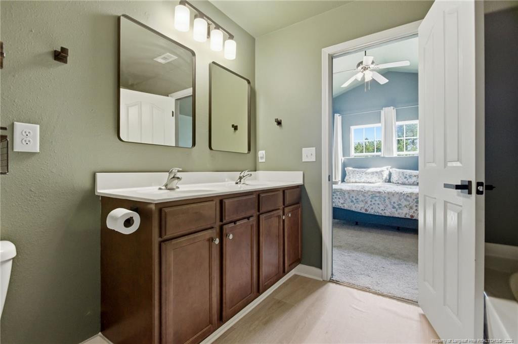 334 Crane Way Bunnlevel, NC 28323 - Photo 33 of 45 a bathroom with a double vanity sink a mirror and bathtub