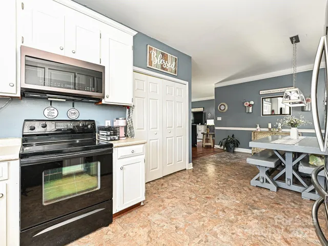 a kitchen with stainless steel appliances granite countertop a stove top oven a sink dishwasher and cabinets with wooden floor