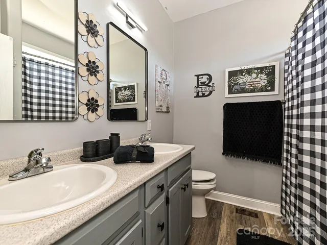 a bathroom with a sink a toilet and mirror
