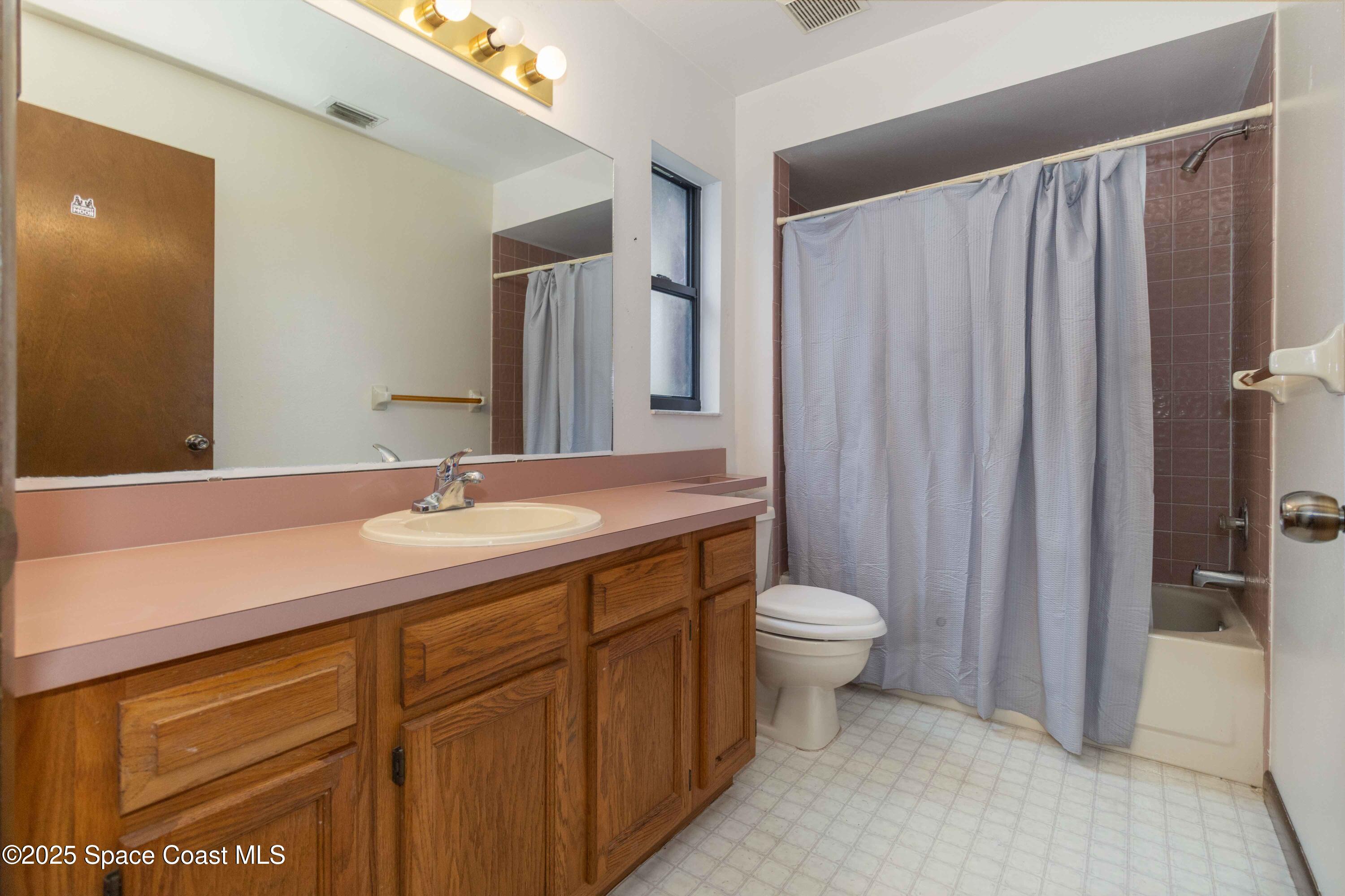 1873 Longleaf Road Cocoa, FL 32926 - Photo 22 of 30 a bathroom with a double vanity sink toilet and a mirror