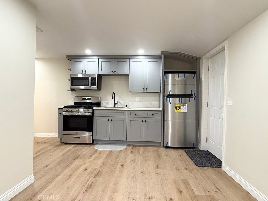 13938 Ragus Street La Puente, CA 91746 - Photo 2 of 6 a kitchen with a refrigerator and a stove top oven