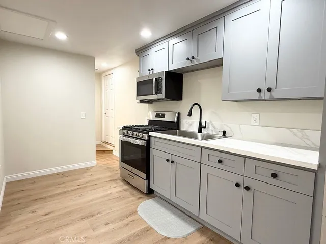 a kitchen with cabinets appliances and a sink