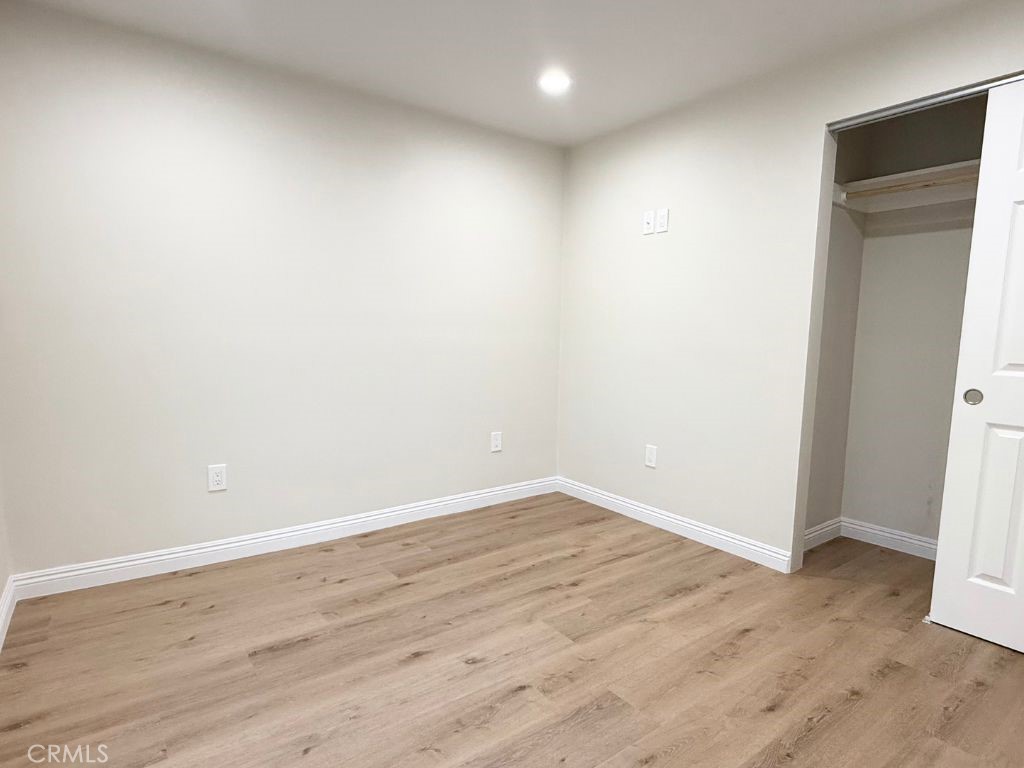 13938 Ragus Street La Puente, CA 91746 - Photo 4 of 6 an empty room with wooden floor and bathroom