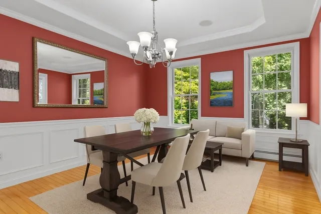 a view of a dining room with furniture a chandelier and wooden floor