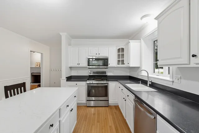 a kitchen with stainless steel appliances granite countertop a sink stove microwave and cabinets