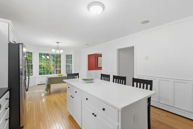 a view of a kitchen with kitchen island a large counter top space a sink stainless steel appliances and cabinets