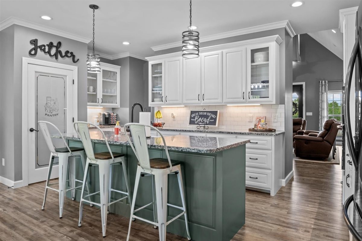 3571 Old Blacktop Road McEwen, TN 37101 - Photo 19 of 99 a kitchen with stainless steel appliances kitchen island granite countertop a table chairs and a refrigerator