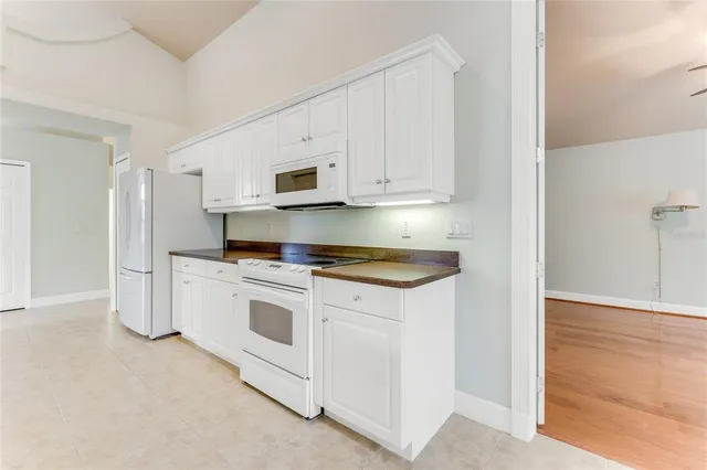 a kitchen with granite countertop white cabinets and window