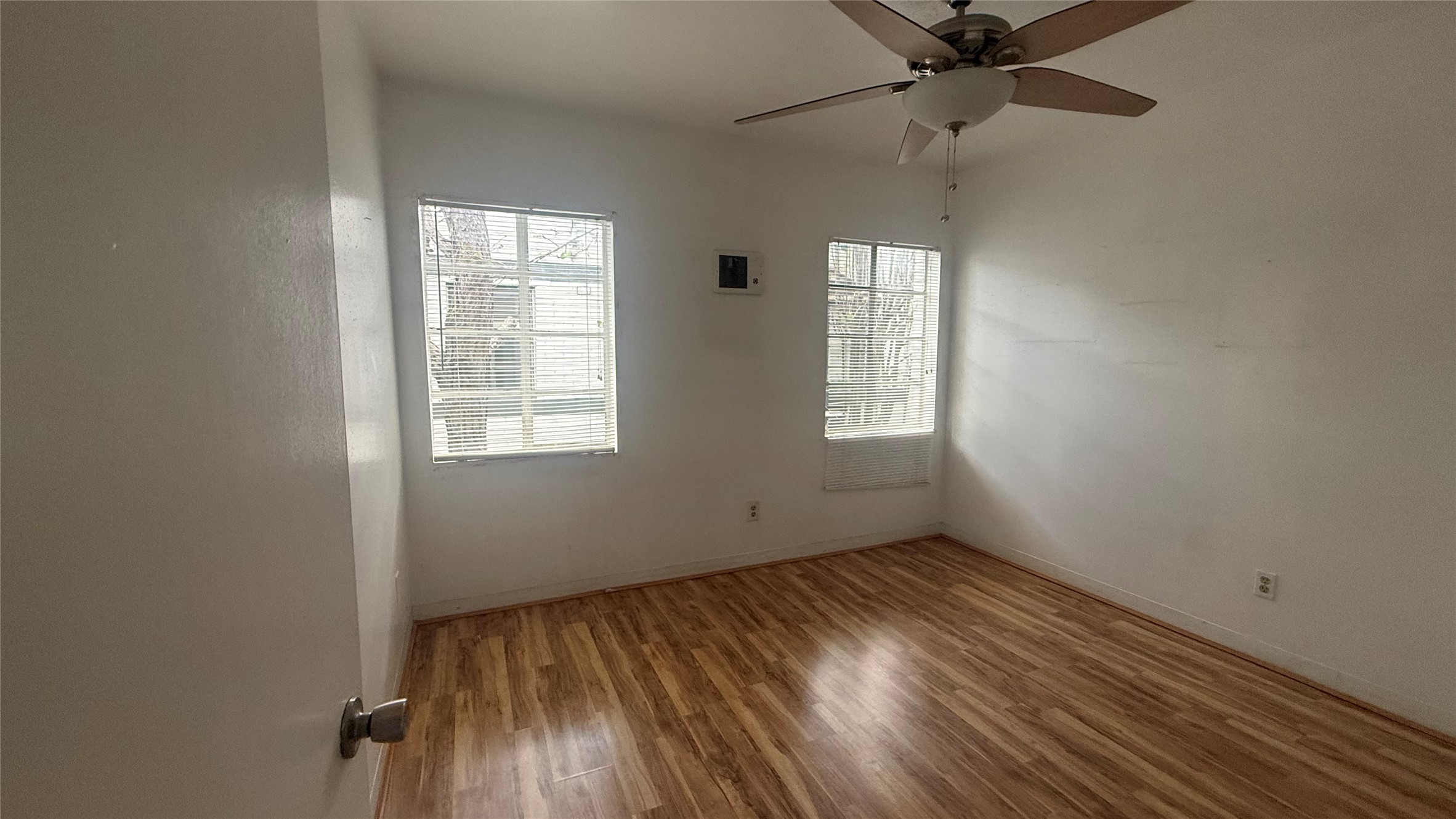 5611 Jackson Street, Unit 11 Houston, TX 77004 - Photo 5 of 7 an empty room with wooden floor fan and windows
