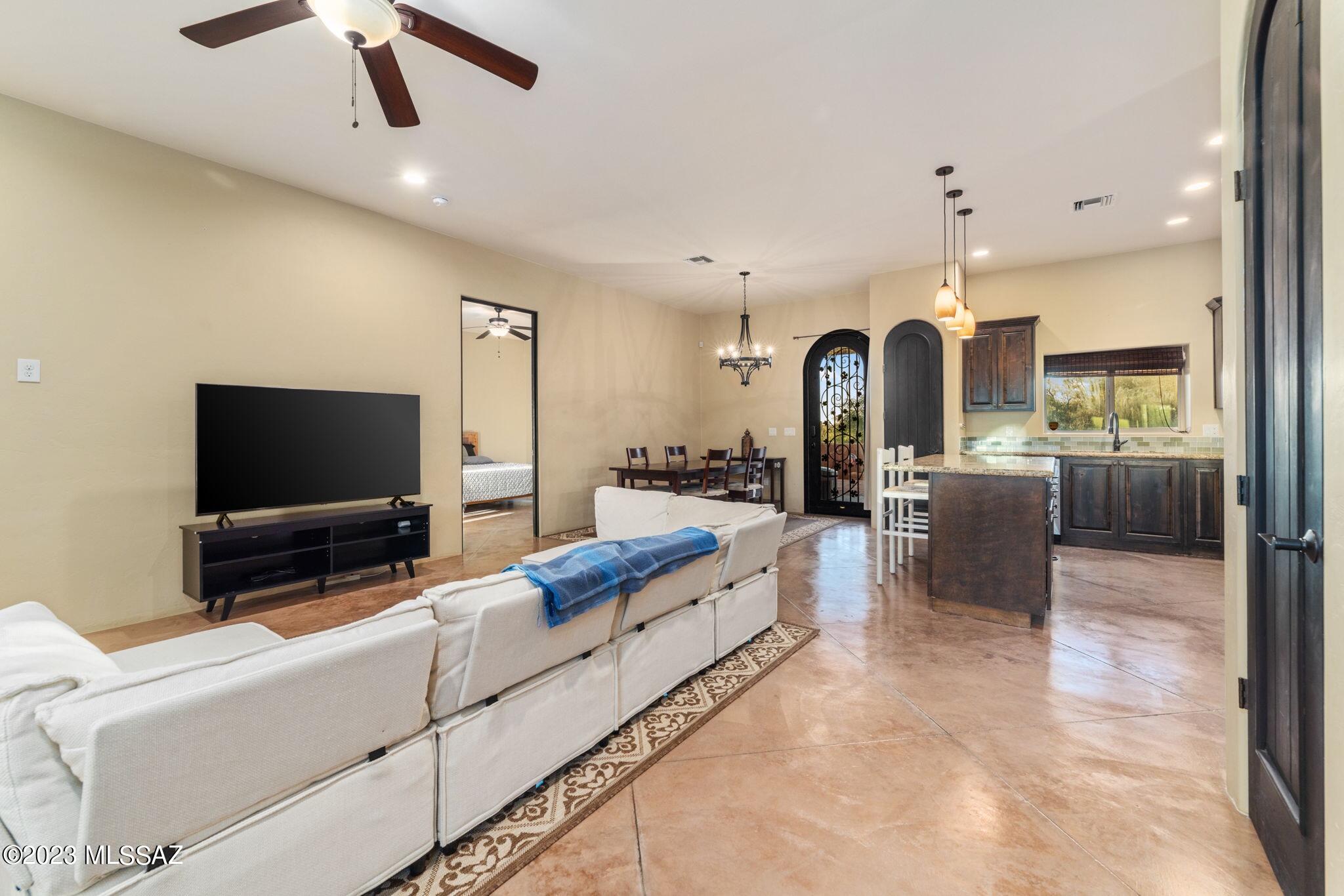 5670 Triangle X Place Tucson, AZ 85713 - Photo 9 of 36 a living room with stainless steel appliances kitchen island granite countertop furniture and a flat screen tv