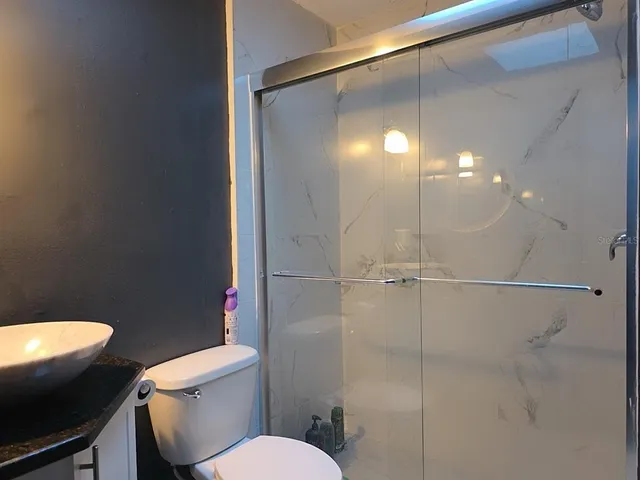 a bathroom with a shower a toilet and a sink