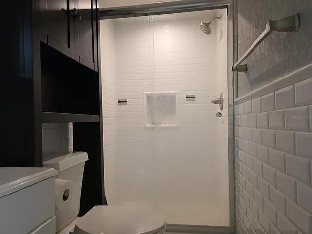 a bathroom with a toilet and a shower
