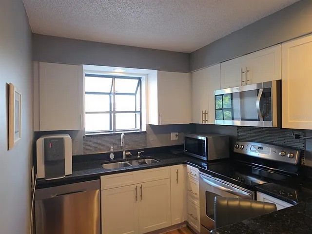 a kitchen with a sink stove and microwave