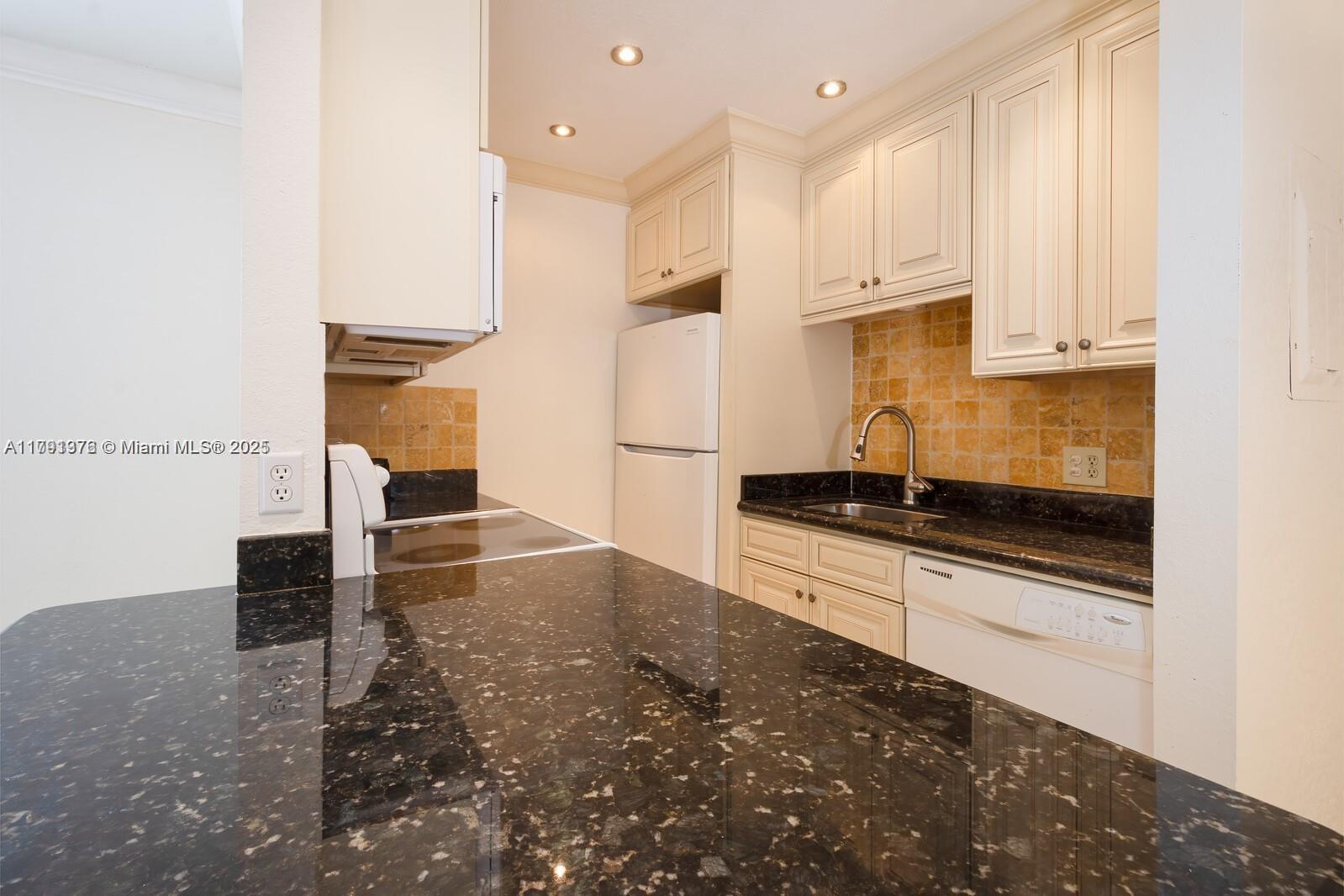 a kitchen with stainless steel appliances granite countertop a sink and a stove