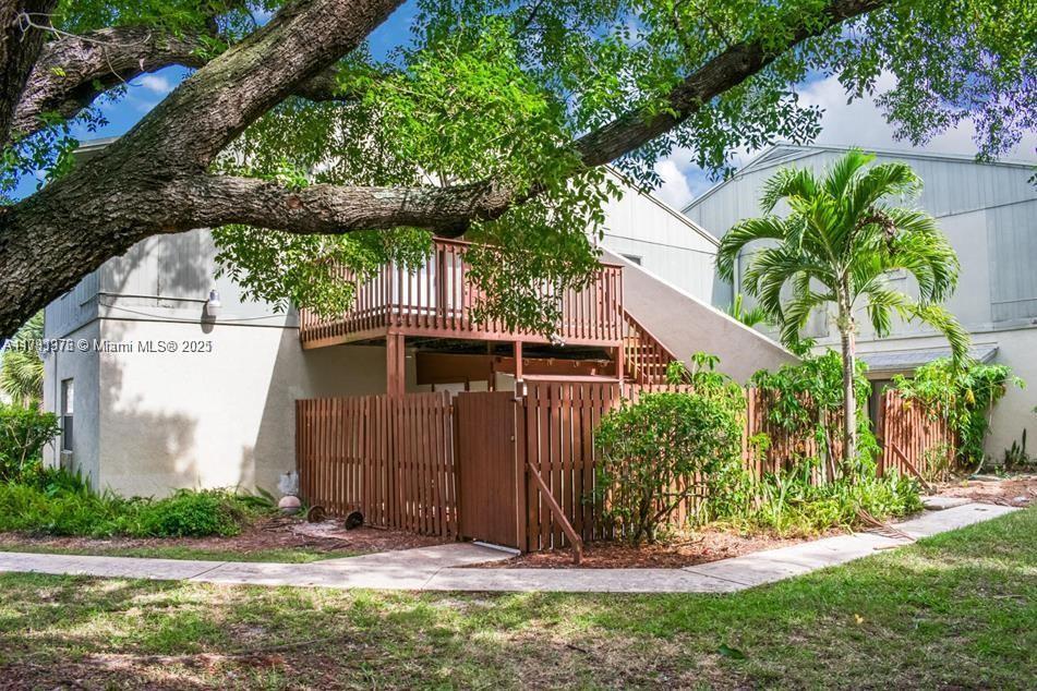1 Crossings Circle, Unit E Boynton Beach, FL 33435 - Photo 12 of 14 a view of a house with a small yard plants and large tree