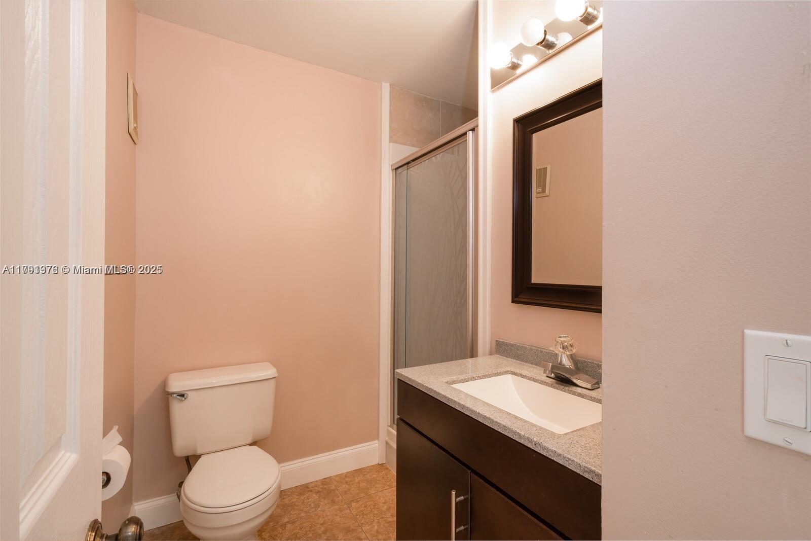 1 Crossings Circle, Unit E Boynton Beach, FL 33435 - Photo 3 of 14 a bathroom with a toilet a sink and mirror