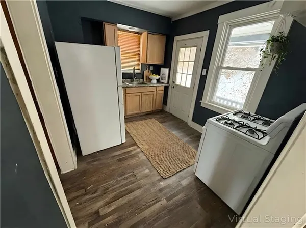 a kitchen with white cabinets and a refrigerator