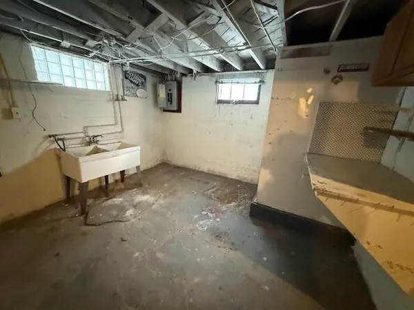 a room with water heater and wooden cabinets